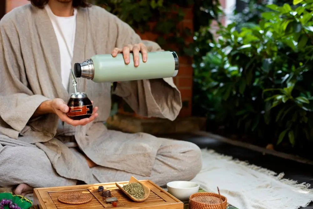 A person holds a halved avocado, preparing fresh ingredients for a healthy smoothie during a detox retreat.