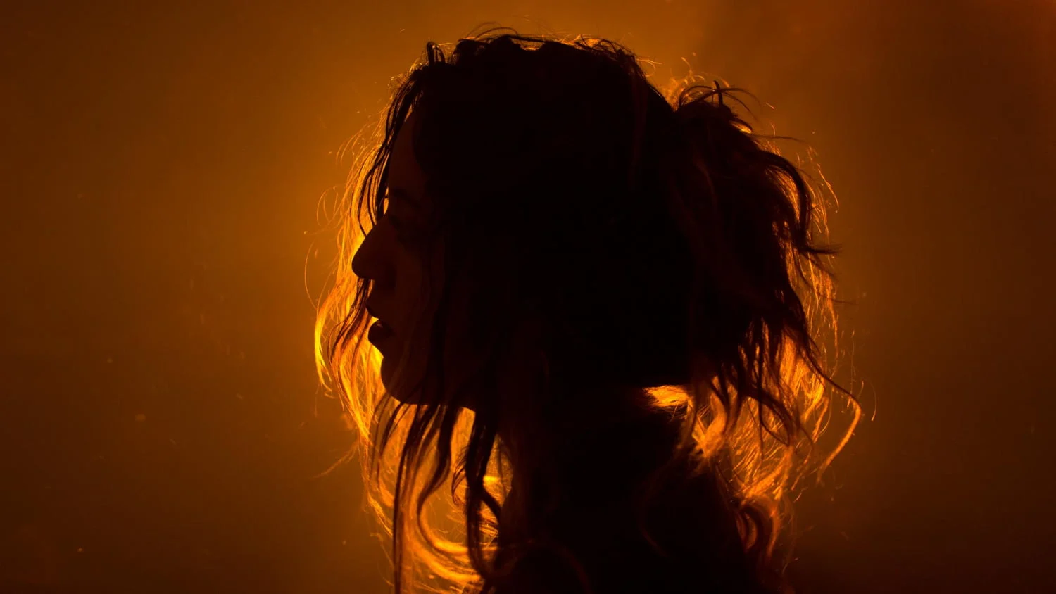 Silhouette of a woman in a glowing golden aura.