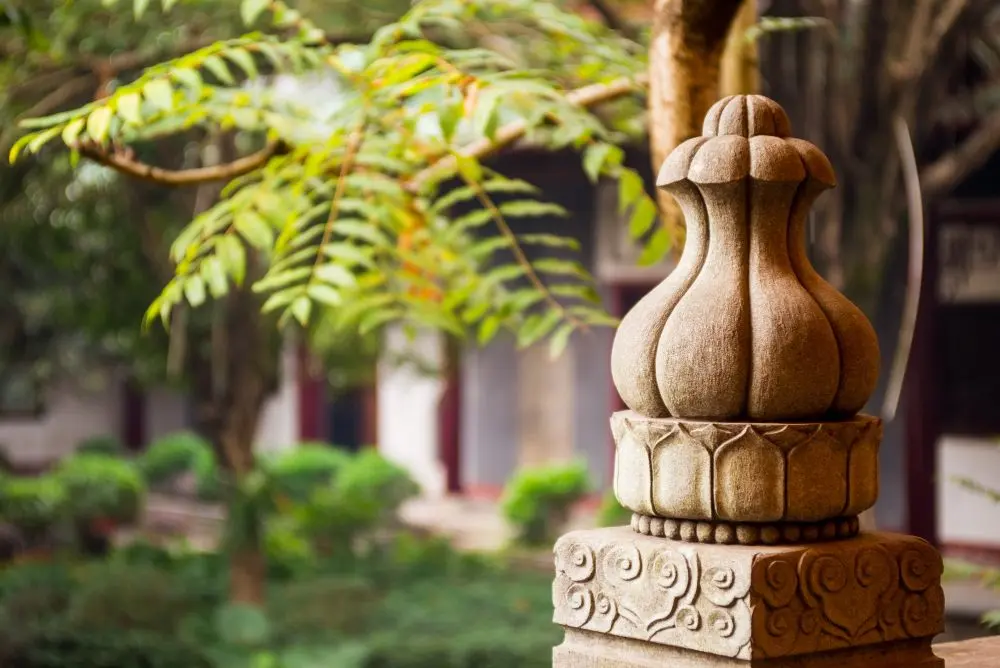 Decorative stone pillar in garden with blurred background