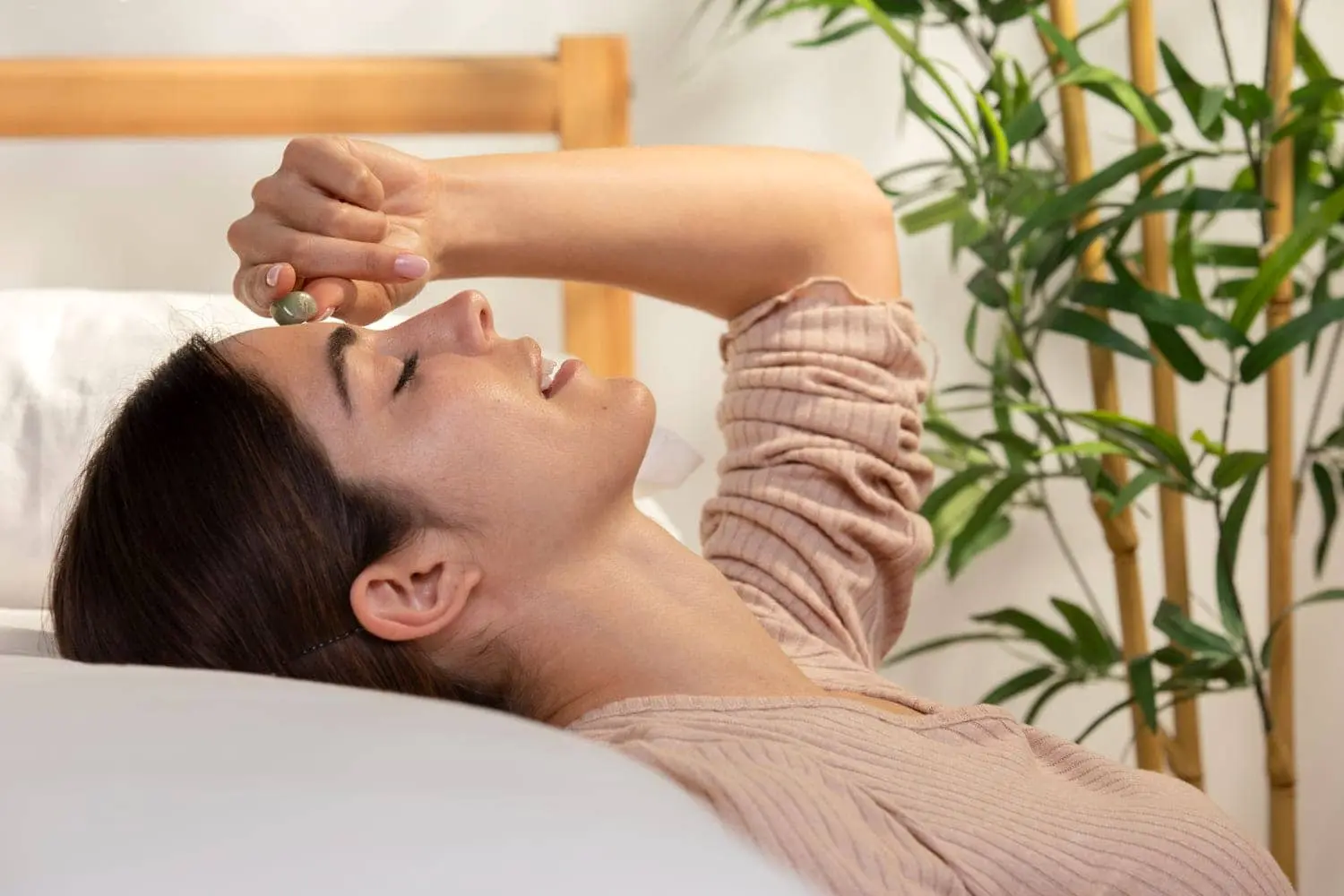 Woman massaging forehead with a healing stone