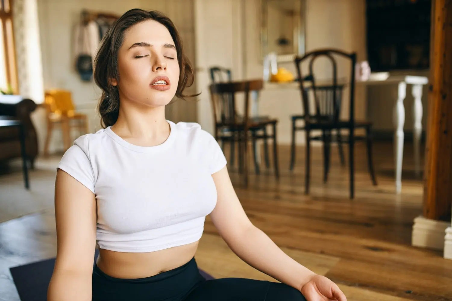 Woman meditating indoors with eyes closed