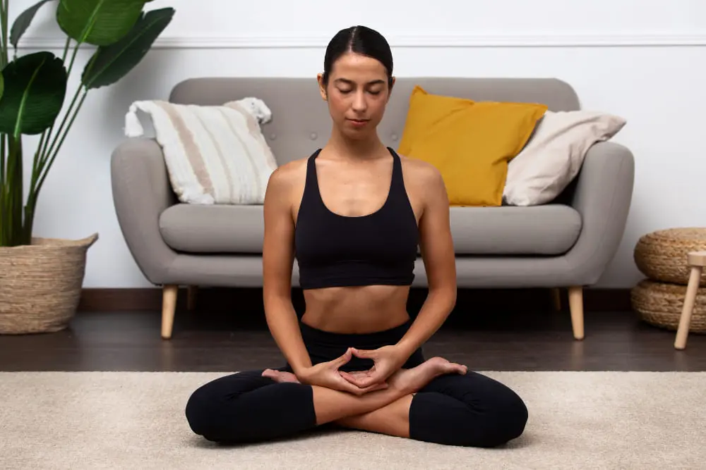 Woman meditating in lotus position on floor
