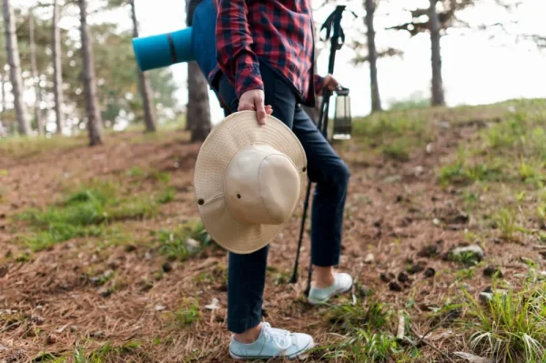 Hiker holding a hat and trekking poles