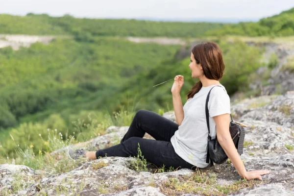 Woman sitting and enjoying a mountain view