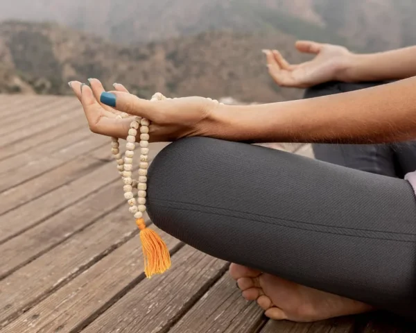 Serene meditation with prayer beads in a peaceful outdoor setting.
