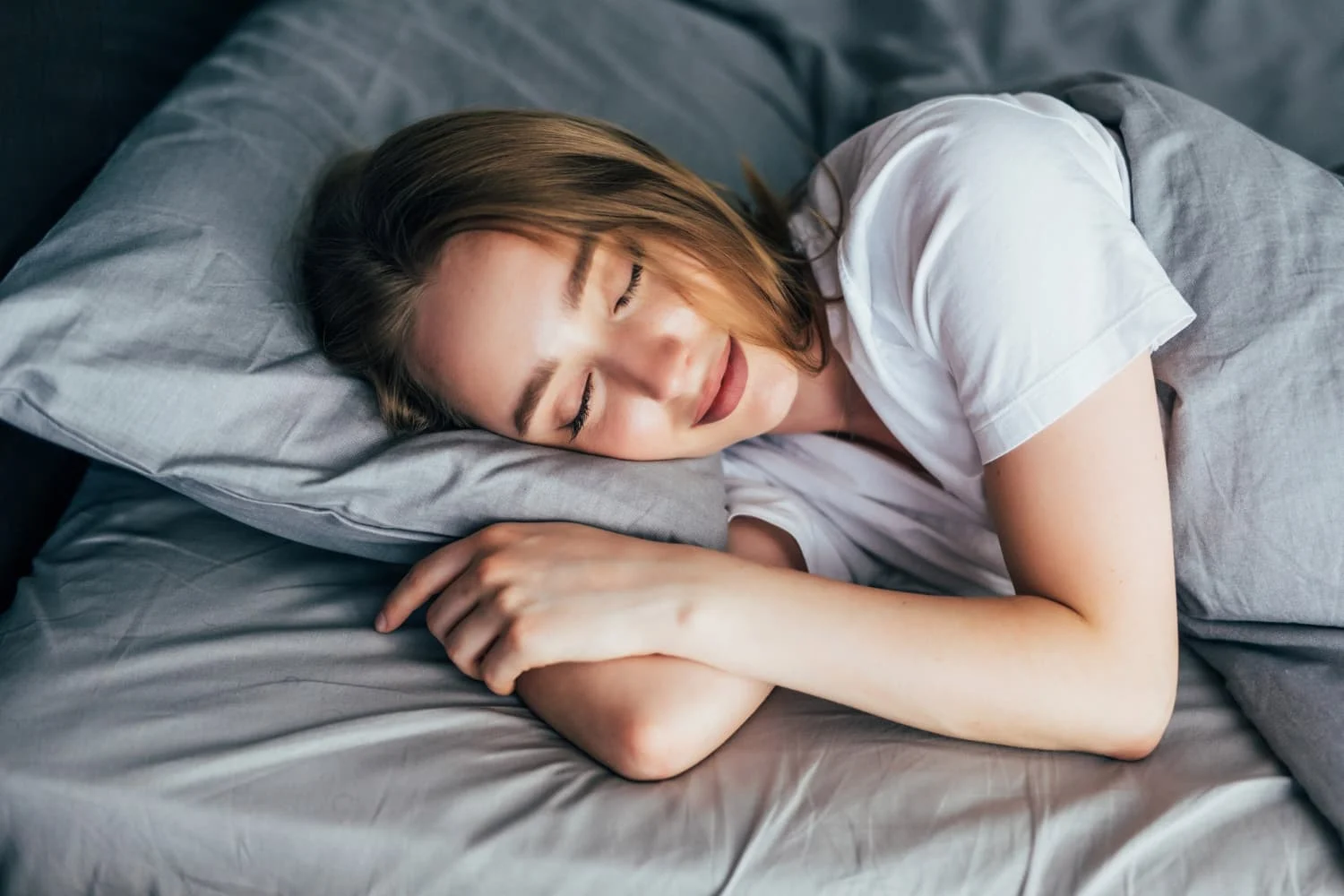 Relaxed young woman sleeping peacefully in bed